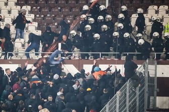 Polizeikräfte drängen randalierende Dresden-Fans zurück in den Gästeblock.