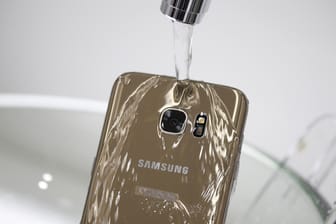 Ein Samsung Galaxy S7 Edge unter dem Wasserhahn: Immer mehr Smartphone-Hersteller werben mit einem wasserfesten Gehäuse. Doch die Angaben sind mit Vorsicht zu genießen.
