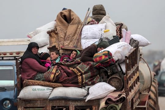 Zivilisten auf der Ladefläche eines Fahrzeugs bei der Flucht aus Idlib.