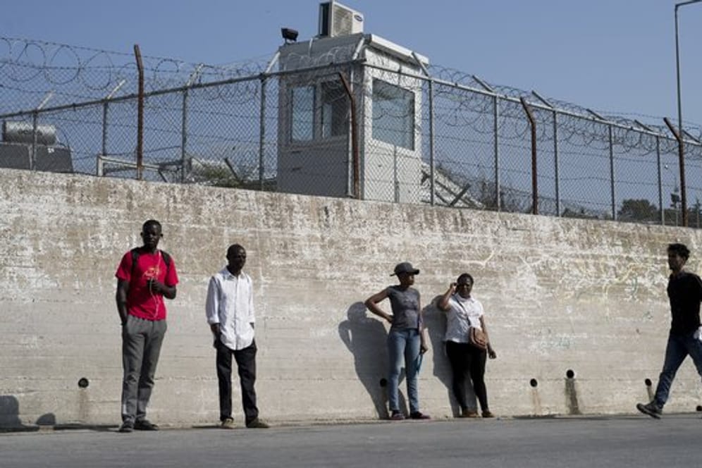 Migranten an einer Mauer des Flüchtlingslagers Moria auf der Insel Lesbos.
