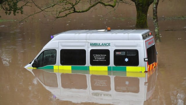 Ein halb im Wasser versunkener Krankenwagen im walisischen Nantgarw. Ein halb im Wasser versunkener Krankenwagen im walisischen Nantgarw.