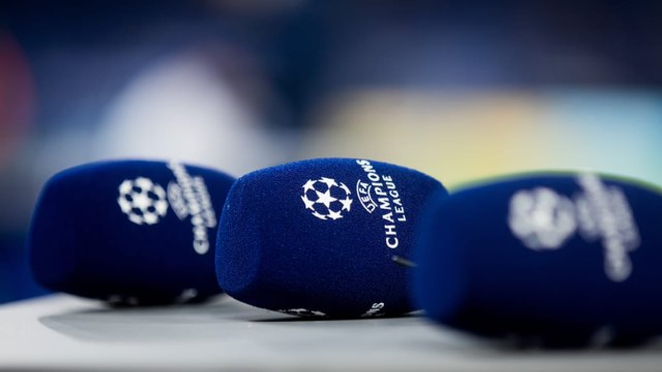 Mikrofone mit dem Logo der Champions League liegen vor einem Spiel auf einem Tisch.
