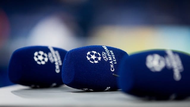 Mikrofone mit dem Logo der Champions League liegen vor einem Spiel auf einem Tisch. Mikrofone mit dem Logo der Champions League liegen vor einem Spiel auf einem Tisch.