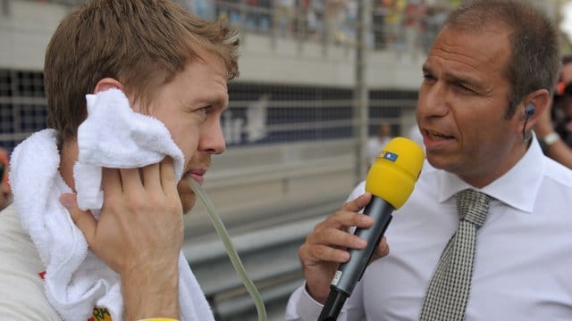 Formel-1-Pilot Sebastian Vettel (l) spricht mit dem TV-Moderator Kai Ebel von RTL vor einem Formel-1-Grand-Prix.