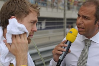 Formel-1-Pilot Sebastian Vettel (l) spricht mit dem TV-Moderator Kai Ebel von RTL vor einem Formel-1-Grand-Prix.