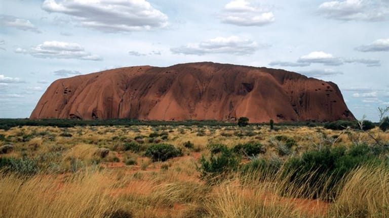 Eines der bekanntesten Wahrzeichen Australiens, der riesige Sandstein Uluru oder Ayers Rock ist in der zentralaustralischen Wüste zu sehen.