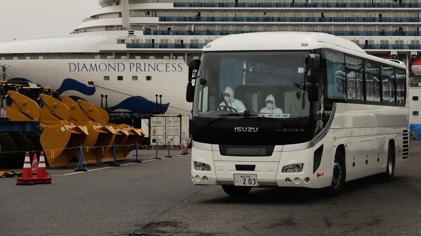 Ein Bus bringt infizierte Passagiere der "Diamond Princess" in Kliniken: Das Kreuzfahrtschiff, auf dem das Coronavirus ausgebrochen ist, liegt im Hafen von Yokohama in Quarantäne.