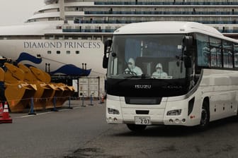 Ein Bus bringt infizierte Passagiere der "Diamond Princess" in Kliniken: Das Kreuzfahrtschiff, auf dem das Coronavirus ausgebrochen ist, liegt im Hafen von Yokohama in Quarantäne.
