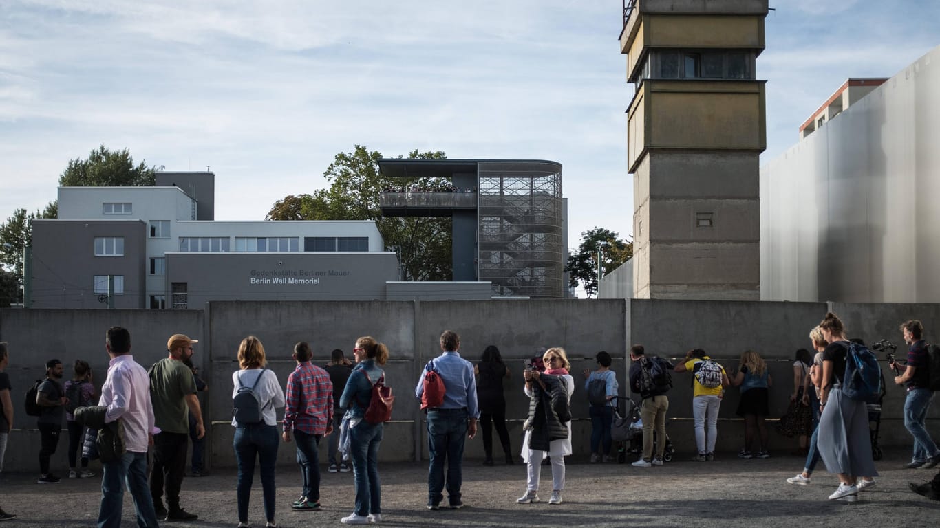 Passanten stehen an Resten der Berliner Mauer an der Gedenkstätte Bernauer Straße: Hier befindet sich der zentrale Erinnerungsort an die deutsche Teilung.