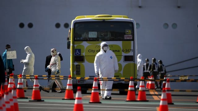 Ein Bus wird inspiziert, bevor die ersten Passagiere des unter Quarantäne stehenden Kreuzfahrtschiffs "Diamond Princess" einsteigen. Ein Bus wird inspiziert, bevor die ersten Passagiere des unter Quarantäne stehenden Kreuzfahrtschiffs "Diamond Princess" einsteigen.