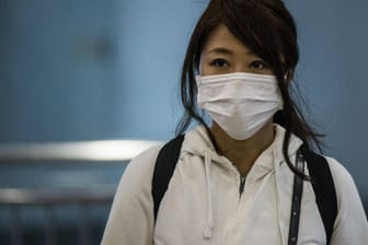 Eine junge Asiatin will sich mit einer Atemschutzmaske vor einer Coronavirus-Infektion schützen: Sie ist keine Chinesin!