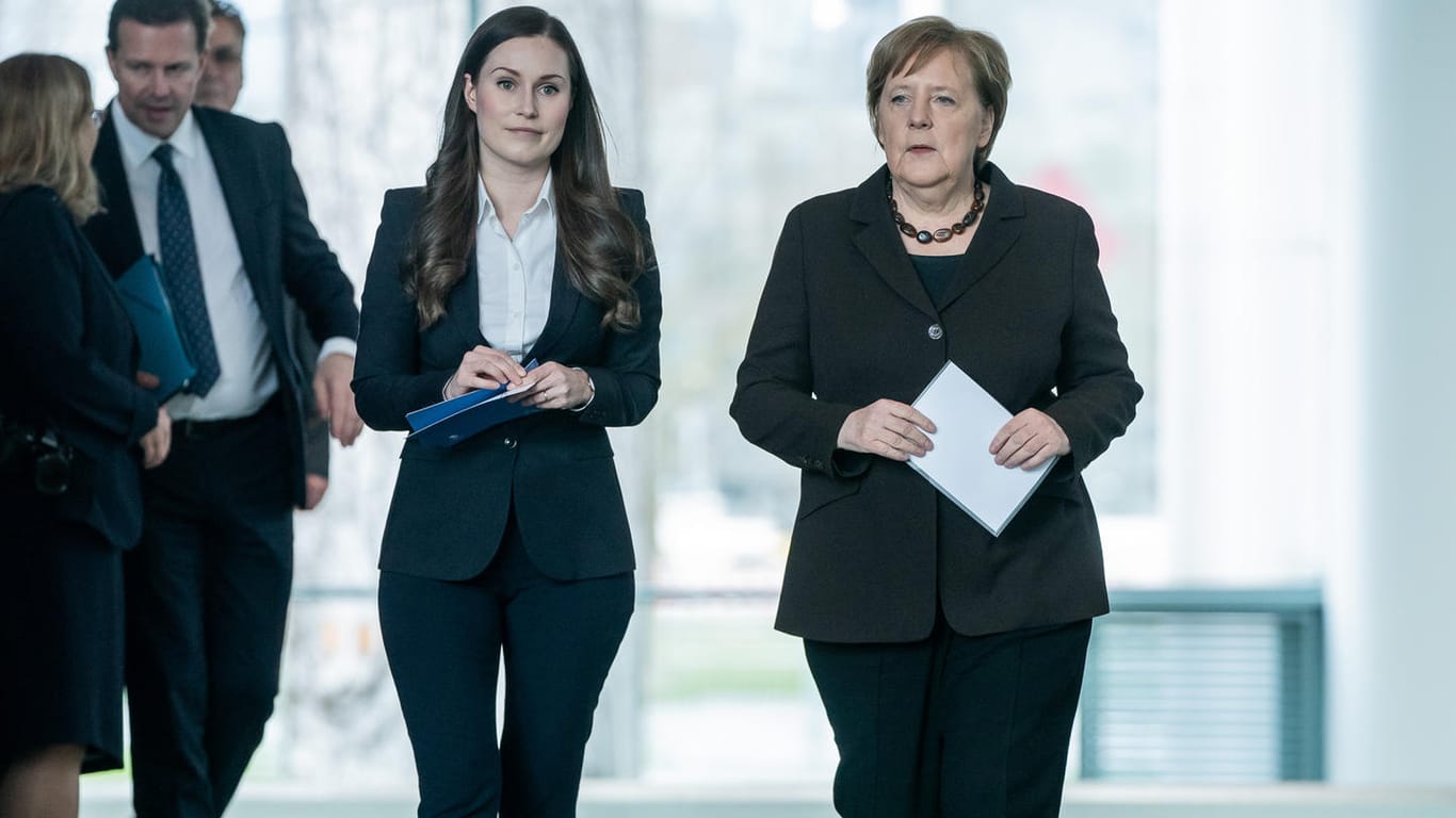 Kanzlerin Angela Merkel (CDU) geht neben Sanna Marin, Ministerpräsidentin von Finnland, bei der Pressekonferenz im Bundeskanzleramt.
