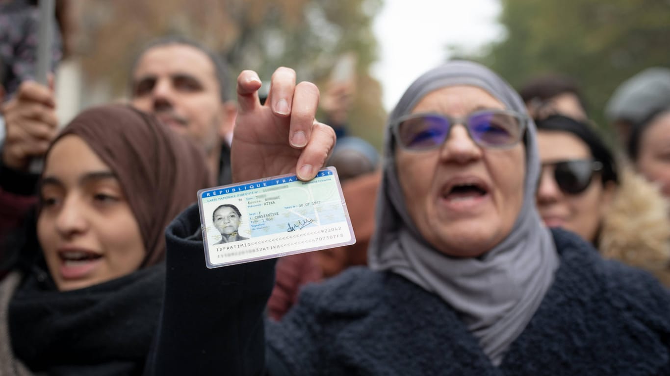 Bei einer Demonstration gegen Islamophobie hält eine Frau ihren französischen Ausweis in die Kamera: "In Frankreich muss man auf Französisch predigen."