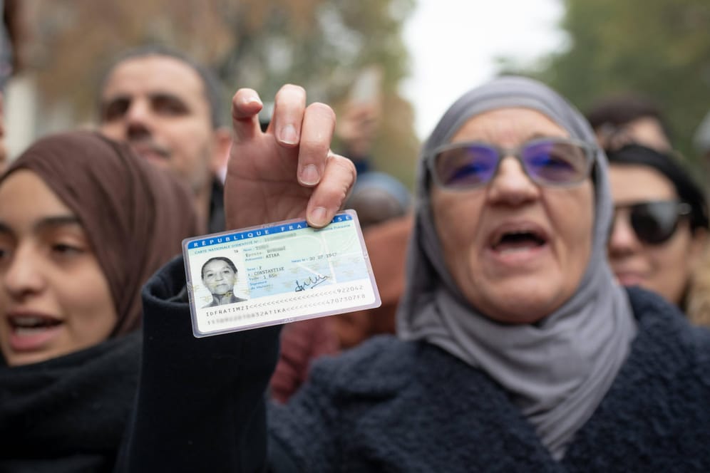 Bei einer Demonstration gegen Islamophobie hält eine Frau ihren französischen Ausweis in die Kamera: "In Frankreich muss man auf Französisch predigen."