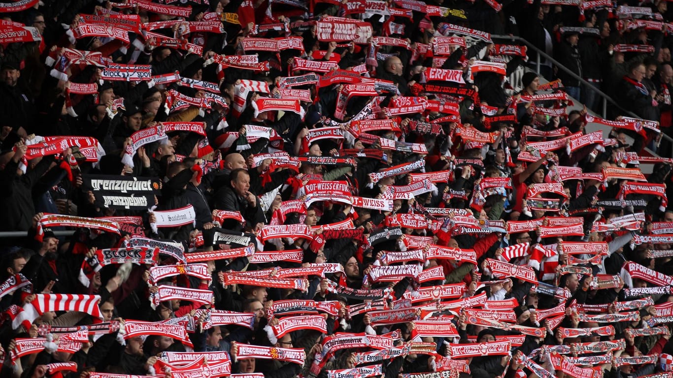 Fans von Rot-Weiß Erfurt halten ihren Schal hoch: Die Profi-Mannschaft musste wegen der Pleite vom Spielbetrieb abgemeldet werden.