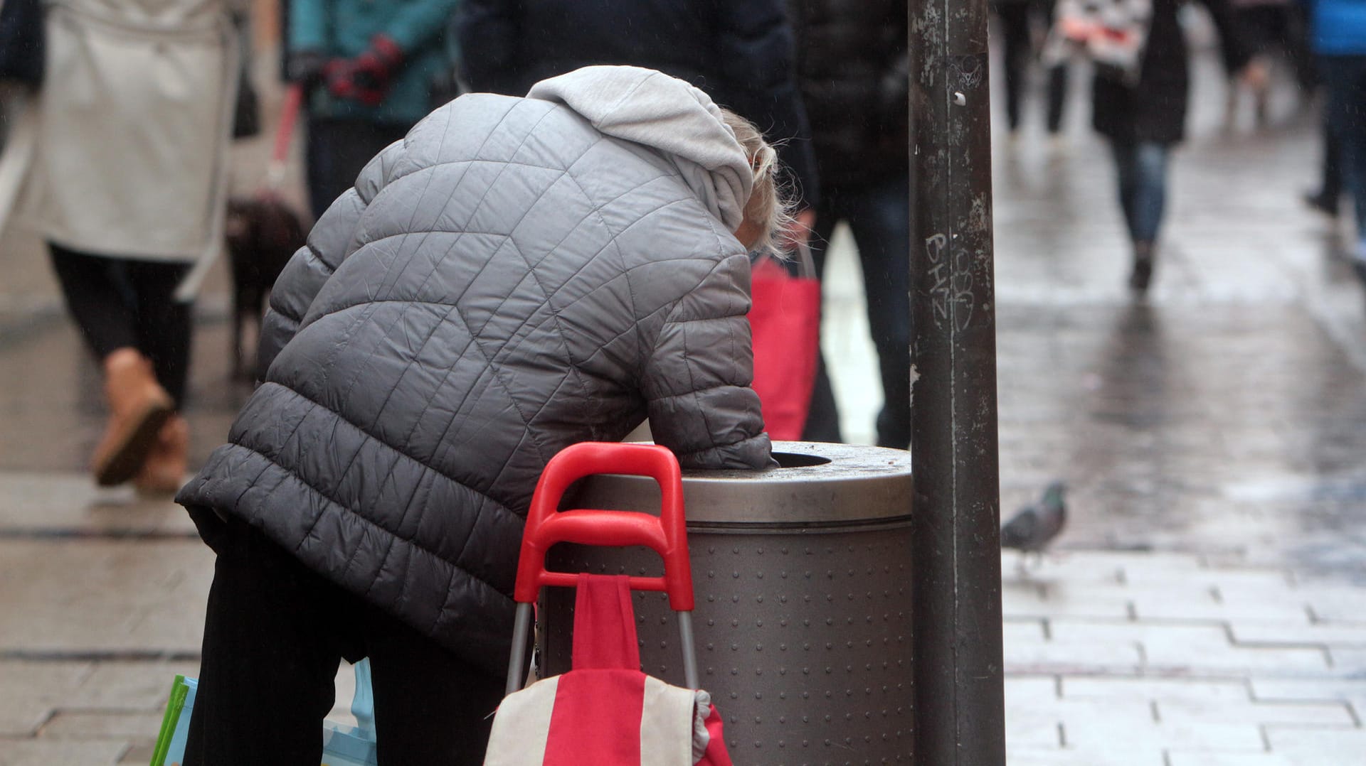 Eine Frau sucht in einem Mülleimer nach Pfandflaschen: Das Sozialgericht in Dortmund hat zugunsten einer Hartz-IV-Empfängerin entschieden. (Symbolbild)