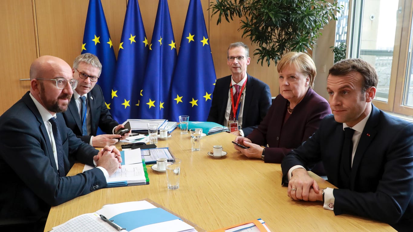 Brüssel: Emmanuel Macron (r), Präsident von Frankreich und die deutsche Bundeskanzlerin Angela Merkel (e.v.r), sprechen mit Charles Michel (l), Präsident des Europäischen Rates, am Rande des EU-Gipfels der Staats- und Regierungschefs.