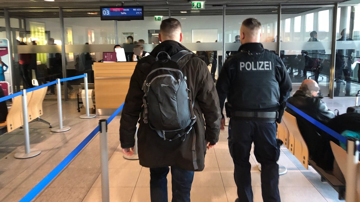 Ein Polizist mit einem mutmaßlichen Rechtsextremen: Bei einem Einsatz am Dortmunder Flughafen wurden zehn Personen die Ausreise nach Sofia verwehrt. Ein Polizist mit einem mutmaßlichen Rechtsextremen: Bei einem Einsatz am Dortmunder Flughafen wurden zehn Personen die Ausreise nach Sofia verwehrt.