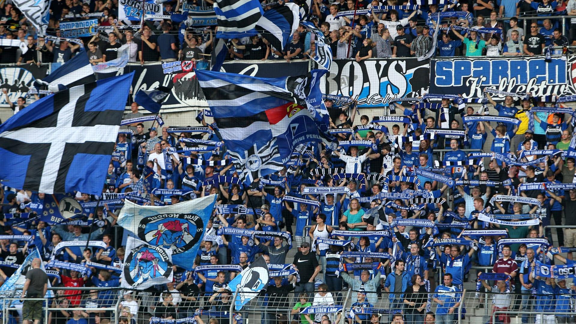 Fans von Arminia Bielefeld halten Schals hoch: Ein Ex-Mitarbeiter des Vereins soll Steuern hinterzogen haben.