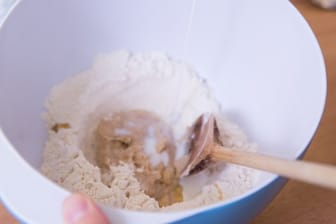 In der Mitte der Mehlkuhle entwickelt sich je nach Rezept mit Milch, Hefe, Butter und Zucker der Vorteig.