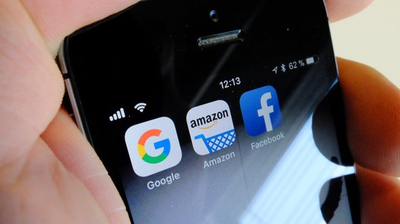Logos für Apps von Google, Amazon und Facebook auf dem Display eines Smartphones.