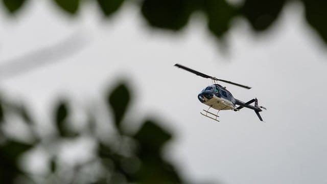 Die Besatzung eines Polizeihubschraubers entdeckte den flüchtigen Unfallfahrer in einem Waldstück neben der Autobahn (Archiv). Die Besatzung eines Polizeihubschraubers entdeckte den flüchtigen Unfallfahrer in einem Waldstück neben der Autobahn (Archiv).