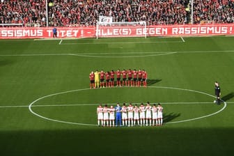 Die Spieler vom SC Freiburg und Fortuna Düsseldorf gedenken in einer Schweigeminute den Opfern der Gewalttat von Hanau.