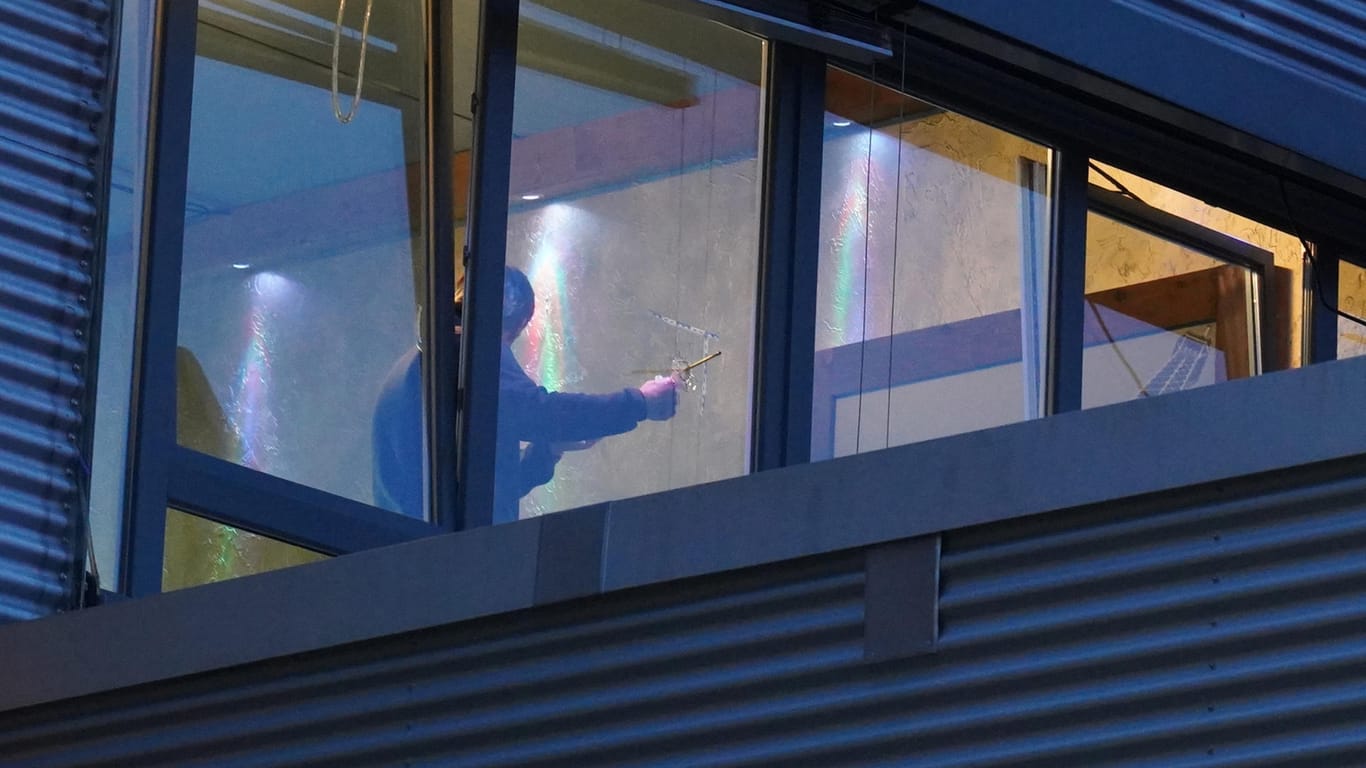 Shisha-Bar in Stuttgart: Ein Ermittler untersucht ein Einschussloch in einer Fensterscheibe.