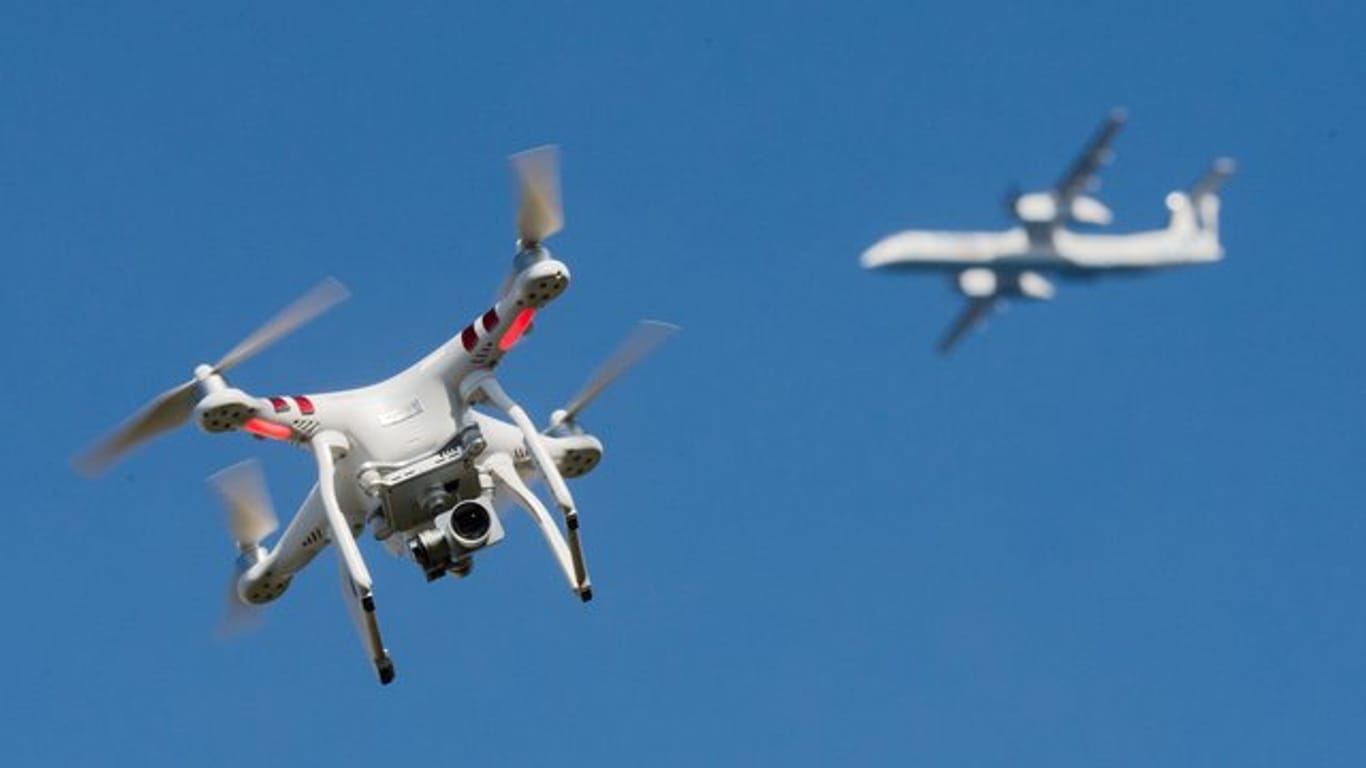 Eine private Drohne fliegt in in der Nähe eines Flugzeugs.