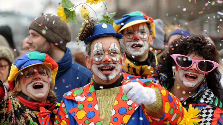 Besucher in Clown-Kostümen werfen mit Konfetti: Karneval findet in diesem Jahr nach dem rassistischen Terror in Hanau unter schweren Umständen statt.