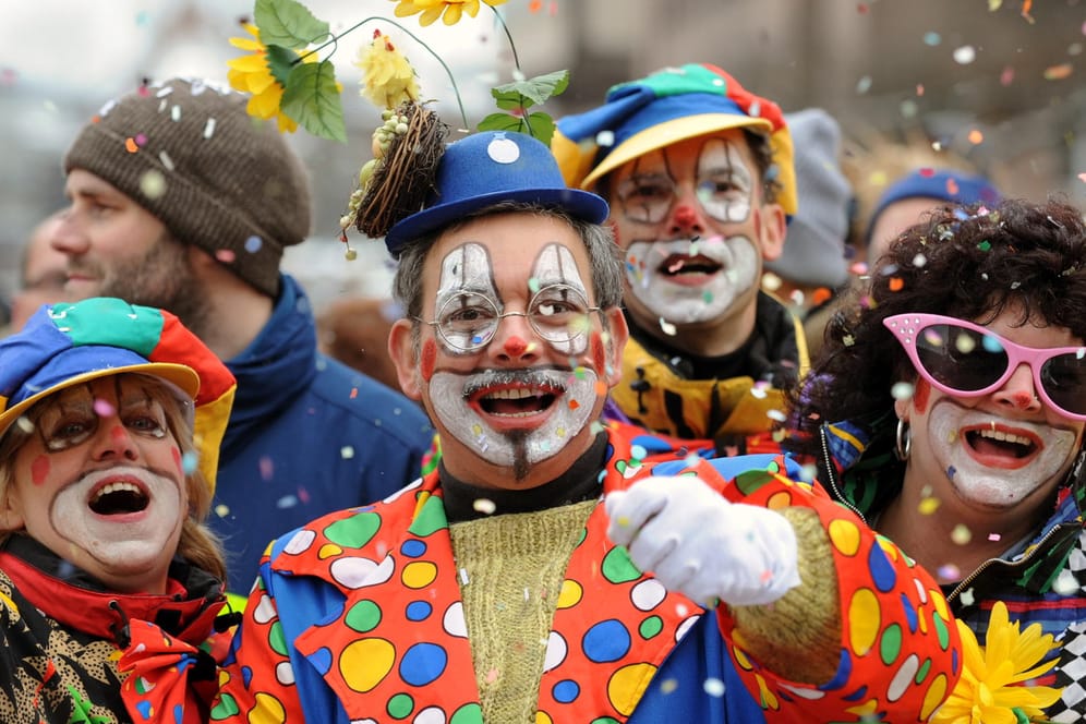 Besucher in Clown-Kostümen werfen mit Konfetti: Karneval findet in diesem Jahr nach dem rassistischen Terror in Hanau unter schweren Umständen statt.