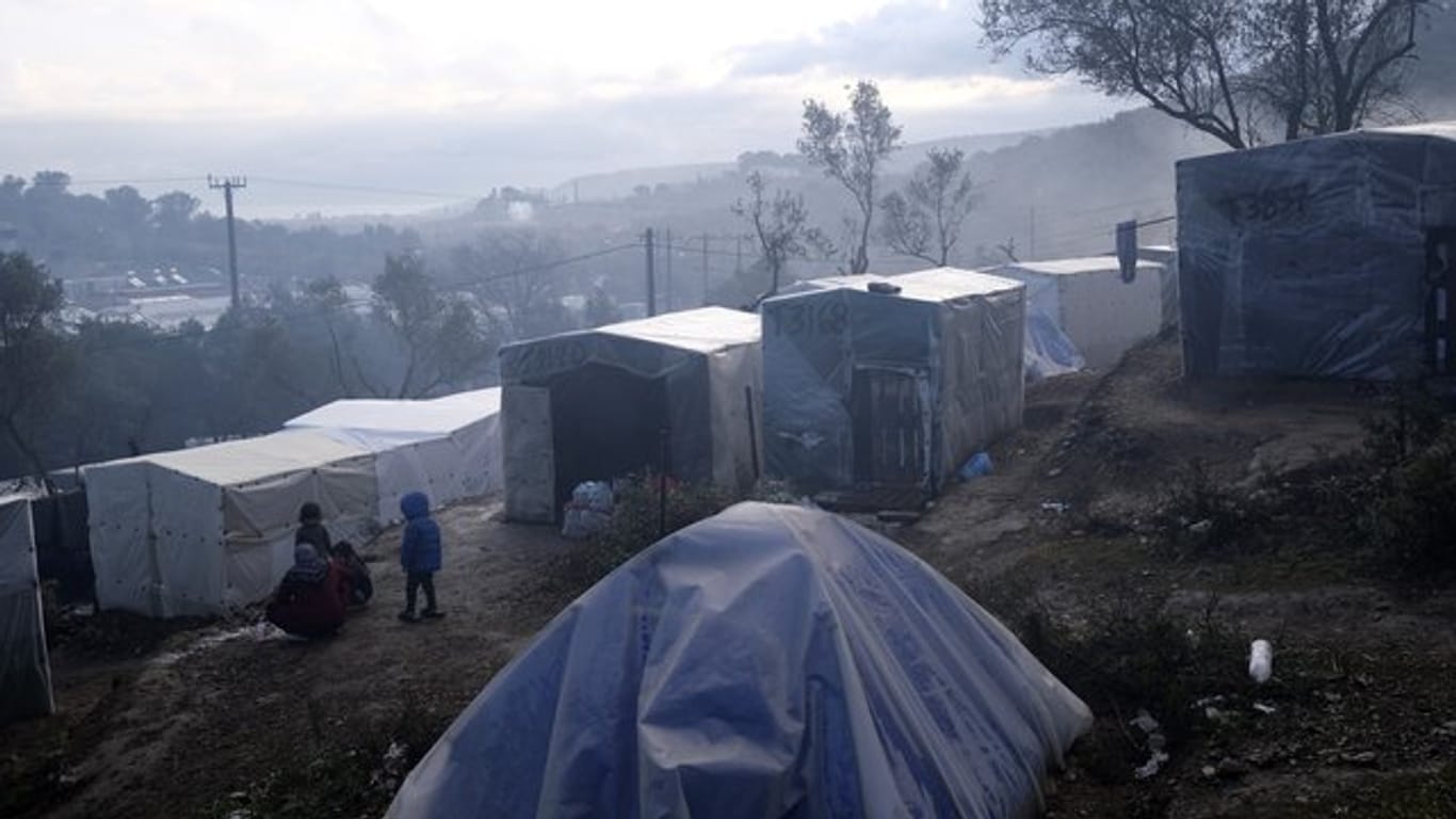 Kinder stehen nach einem Regenguss vor provisorisch errichteten Zelten außerhalb des Flüchtlingslagers Moria auf Lesbos.