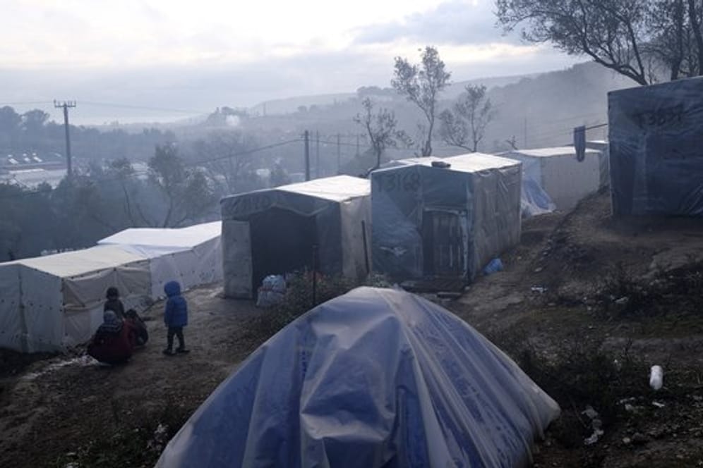 Kinder stehen nach einem Regenguss vor provisorisch errichteten Zelten außerhalb des Flüchtlingslagers Moria auf Lesbos.