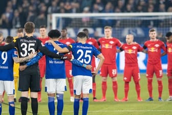 Die Teams von Schalkes und Leipzig nehmen an einer Gedenkminute teil.