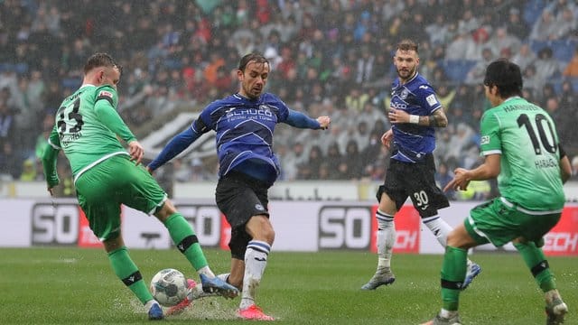 Die Spieler von Arminia Bielefeld und Hannover 96 kämpfen in der Schüco-Arena auf durchweichtem Rasen um den Ball. Die Spieler von Arminia Bielefeld und Hannover 96 kämpfen in der Schüco-Arena auf durchweichtem Rasen um den Ball.