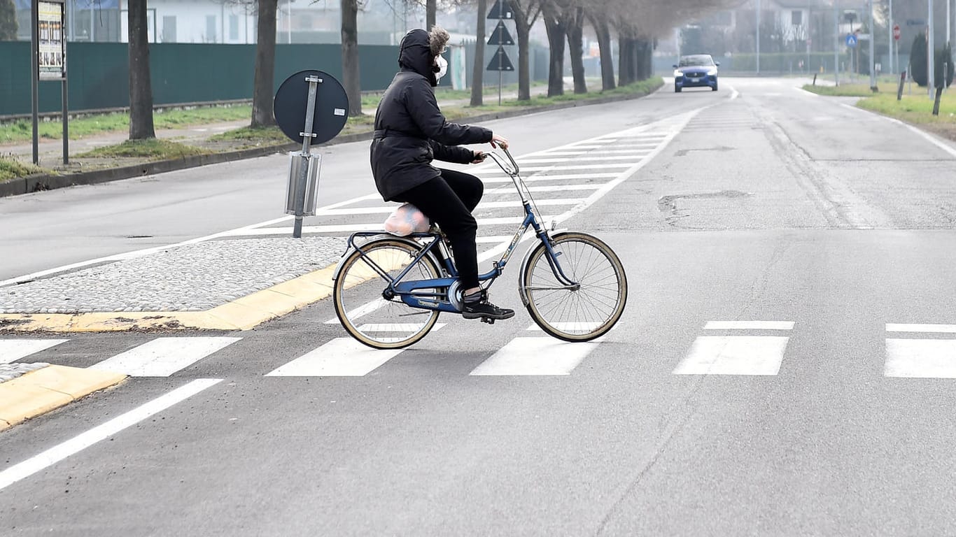 Ein Radfahrer auf einer menschenleeren Straße in Codogno: Wegen des Coronavirus-Ausbruchs hat die Polizei die Stadt abgeriegelt.