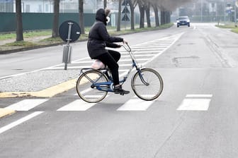 Ein Radfahrer auf einer menschenleeren Straße in Codogno: Wegen des Coronavirus-Ausbruchs hat die Polizei die Stadt abgeriegelt.