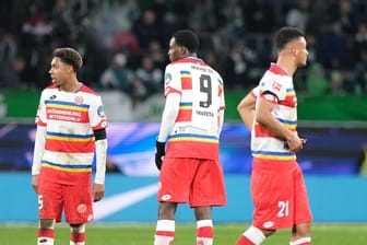 Getrübte Stimmung: Die Mainzer Jean-Paul Boetius (l-r), Jean-Philippe Mateta und Karim Onisiwo bleiben nach dem Schlusspfiff nach auf dem Spielfeld.