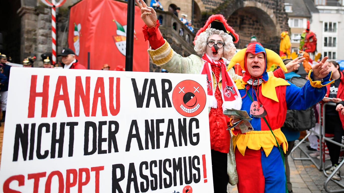 Karnevalisten erinnern vor Beginn des Rosenmontagszuges an die Ereignisse in Hanau.