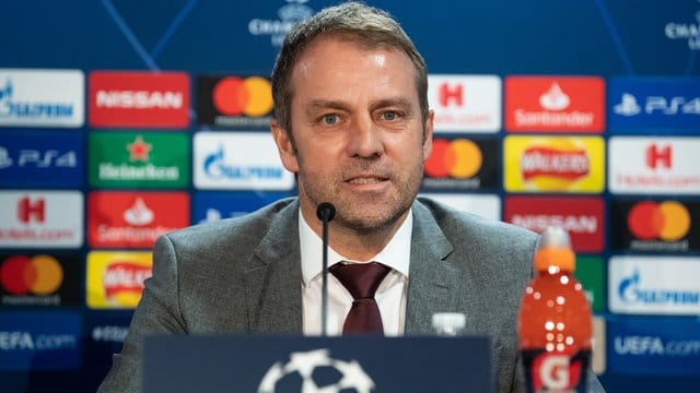 Bayern-Trainer Hansi Flick sitzt an seinem Geburtstag bei der Pressekonferenz zum Chelsea-Spiel auf dem Podium.