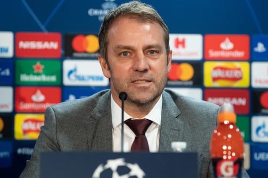 Bayern-Trainer Hansi Flick sitzt an seinem Geburtstag bei der Pressekonferenz zum Chelsea-Spiel auf dem Podium.