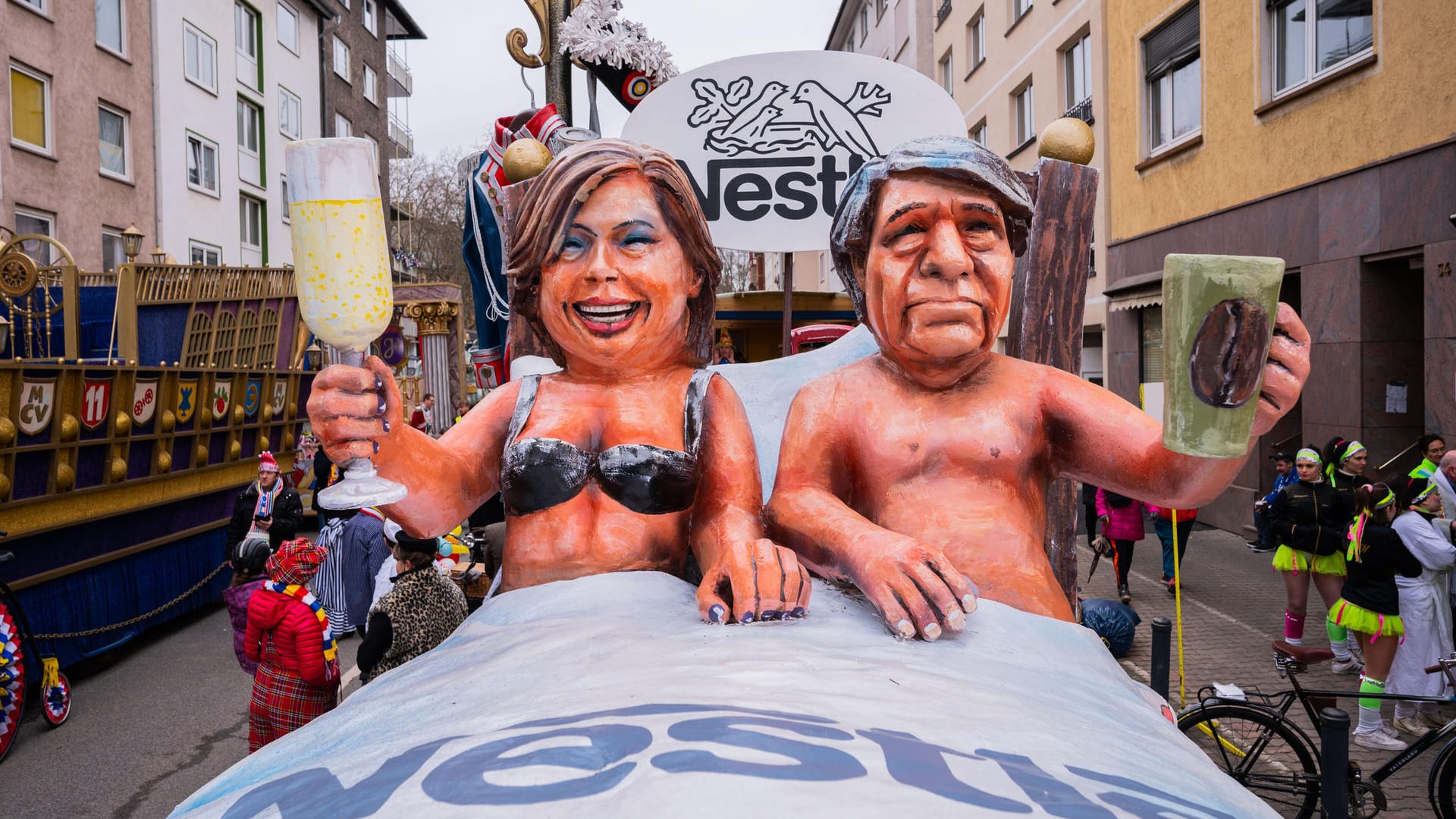 Zwei Pappmache-Figuren: Sie zeigen Julia Klöckner (CDU), Bundeslandwirtschaftsministern, und Marc Boersch, Deutschlandchef von Nestle, gemeinsam in einem Bett auf einem Zugwagen in Mainz.