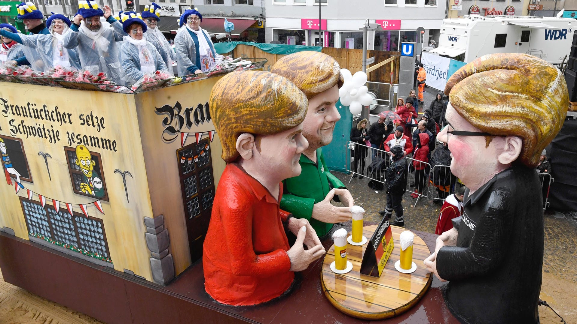 Rosenmontag in Köln: Ein Motivwagen des Rosenmontagszugs zeigt einen "Kanzlerstammtisch", an dem Armin Laschet (CDU, r), der Grünen-Vorsitzende Robert Habeck (M) und Finanzminister Olaf Scholz (SPD) sitzen.