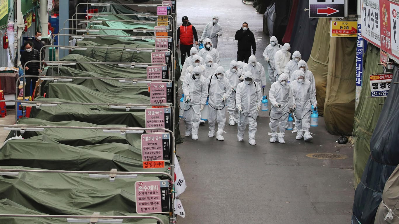 Arbeiter mit Schutzanzügen auf einem Markt in Südkorea: Der Ausbruch dort alarmiert Experten.
