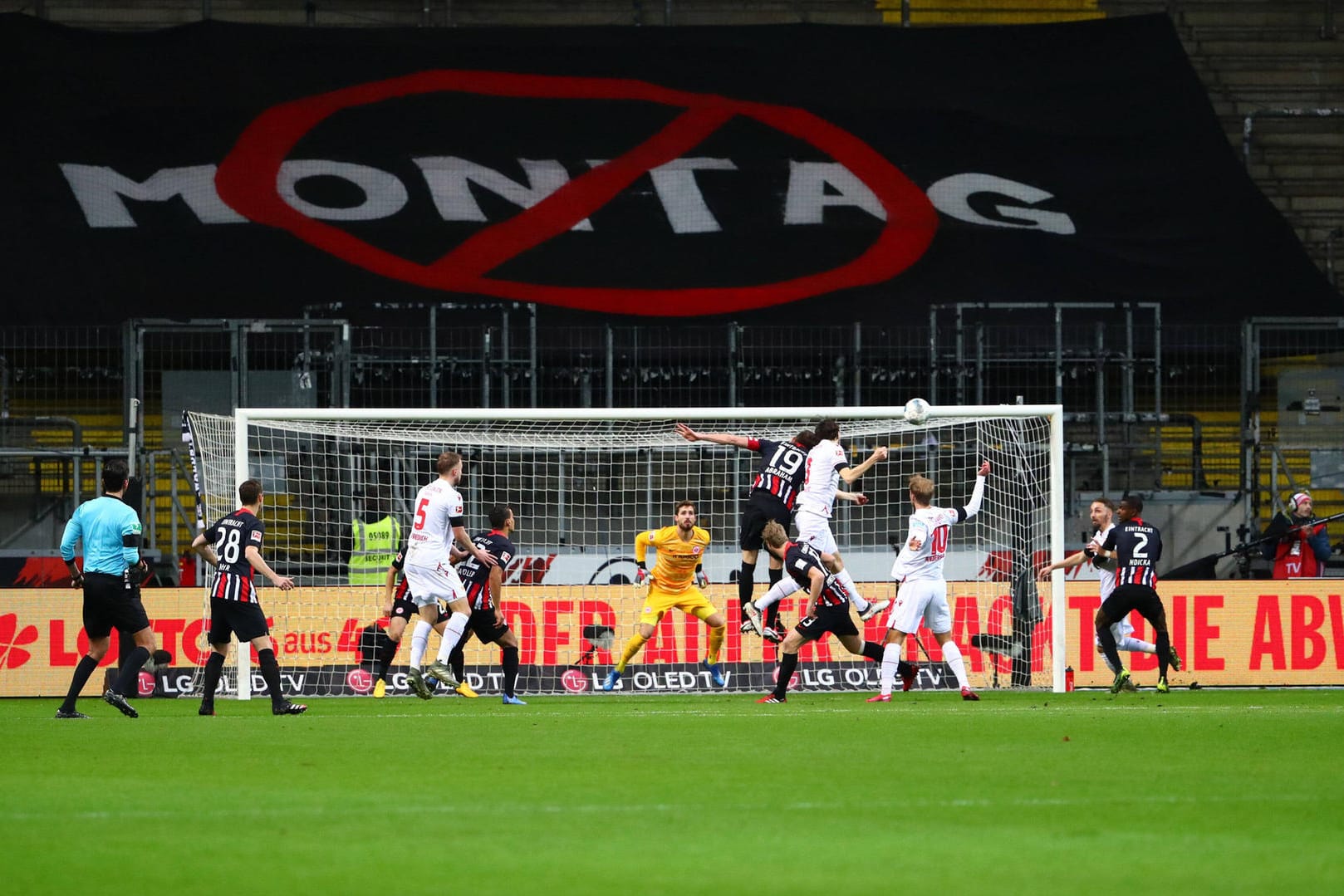 Bundesliga: Zweikampf vor dem leeren Frankfurter Stehblock und dem Protestbanner gegen Montagspiele.