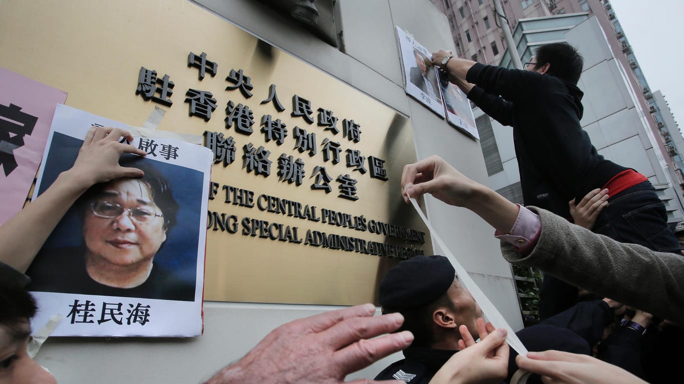Demonstranten in Hongkong versuchen ein Foto von Gui Minhai an dem Regierungssitz zu befestigen: Der Publizist wurde in China zu zehn Jahren Haft verurteilt.