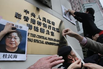 Demonstranten in Hongkong versuchen ein Foto von Gui Minhai an dem Regierungssitz zu befestigen: Der Publizist wurde in China zu zehn Jahren Haft verurteilt.