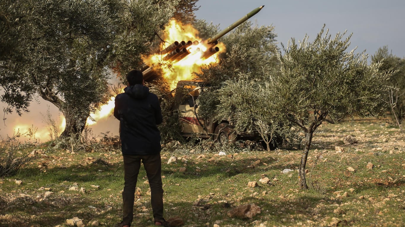 Ein Kämpfer der Nationalen Befreiungsfront sieht zu, wie während eines Großangriffs durch Oppositionsaktivisten auf syrische Regierungstruppen eine Rakete abgefeuert wird.