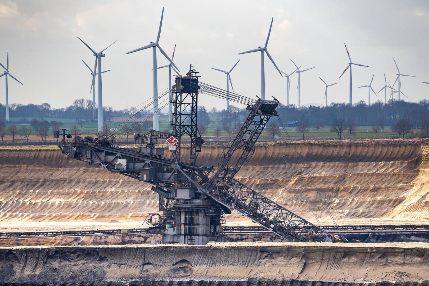 Der Braunkohletagebau im Garzweiler (Nordrhein-Westfalen) steht im Kontrast zu den Windkraftanlagen. Deutsche Konzerne investieren laut einer neuen Studie mehr in erneuerbare Energien. Der Braunkohletagebau im Garzweiler (Nordrhein-Westfalen) steht im Kontrast zu den Windkraftanlagen. Deutsche Konzerne investieren laut einer neuen Studie mehr in erneuerbare Energien.