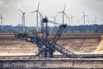 Der Braunkohletagebau im Garzweiler (Nordrhein-Westfalen) steht im Kontrast zu den Windkraftanlagen. Deutsche Konzerne investieren laut einer neuen Studie mehr in erneuerbare Energien.